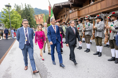 LH Platter, LH Kompatscher und LH Fugatti sowie BMin Schramböck, Alpbach Präsident Treichl und Bischof Glettler schreiten Ehrenformation beim Landesüblichen Empfang in Alpbach ab.