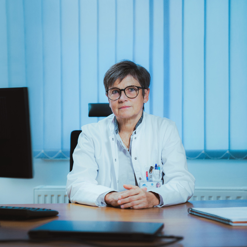 Ärztin sitzt am Schreibtisch