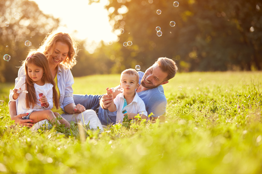 Familie sitzt im Gras