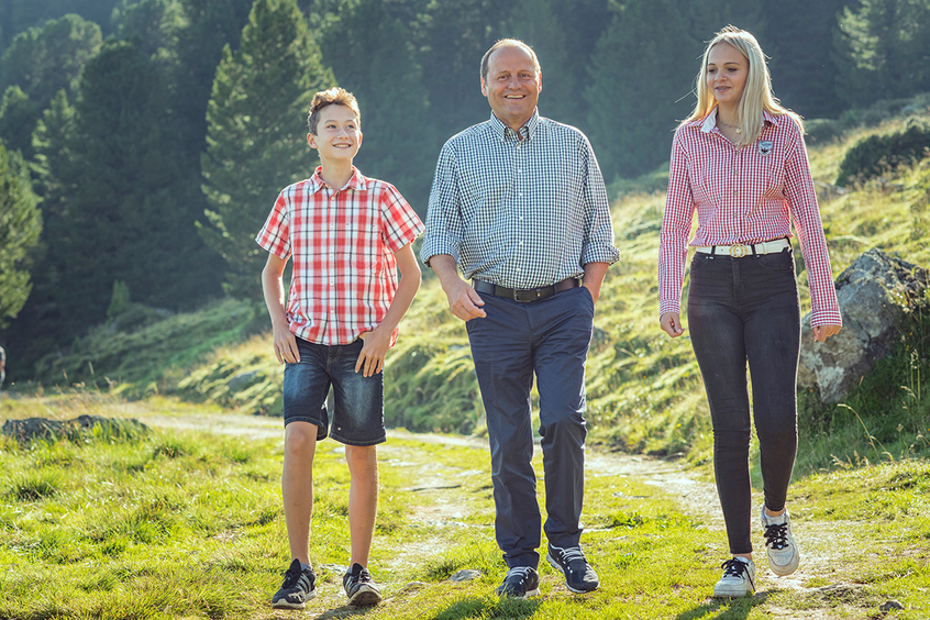 LHStv Josef Geisler geht mit zwei Jugendlichen einen Weg entlang.