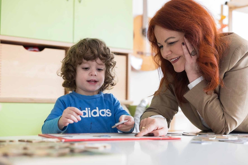 Landesrätin Cornelia Hagele mit einem kleinen Kind beim Lesen.