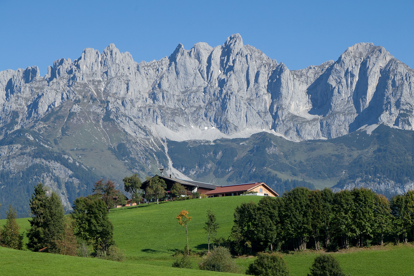 Berge mit Haus und Bäumen im Vordergrund