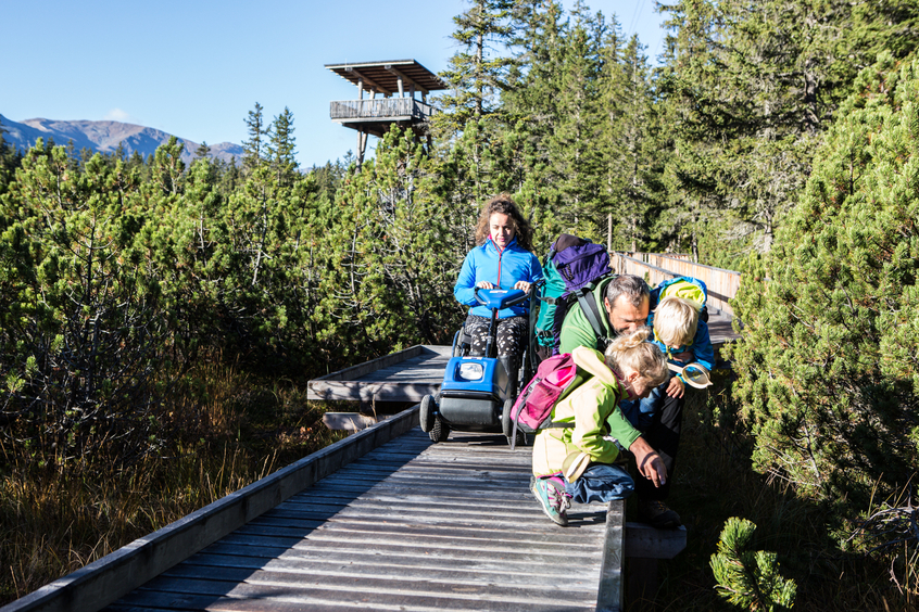 Familie auf Wanderweg aus Holzplanken