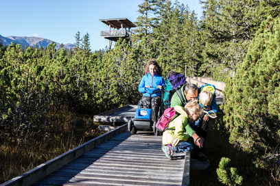 Familie auf Wanderweg aus Holzplanken